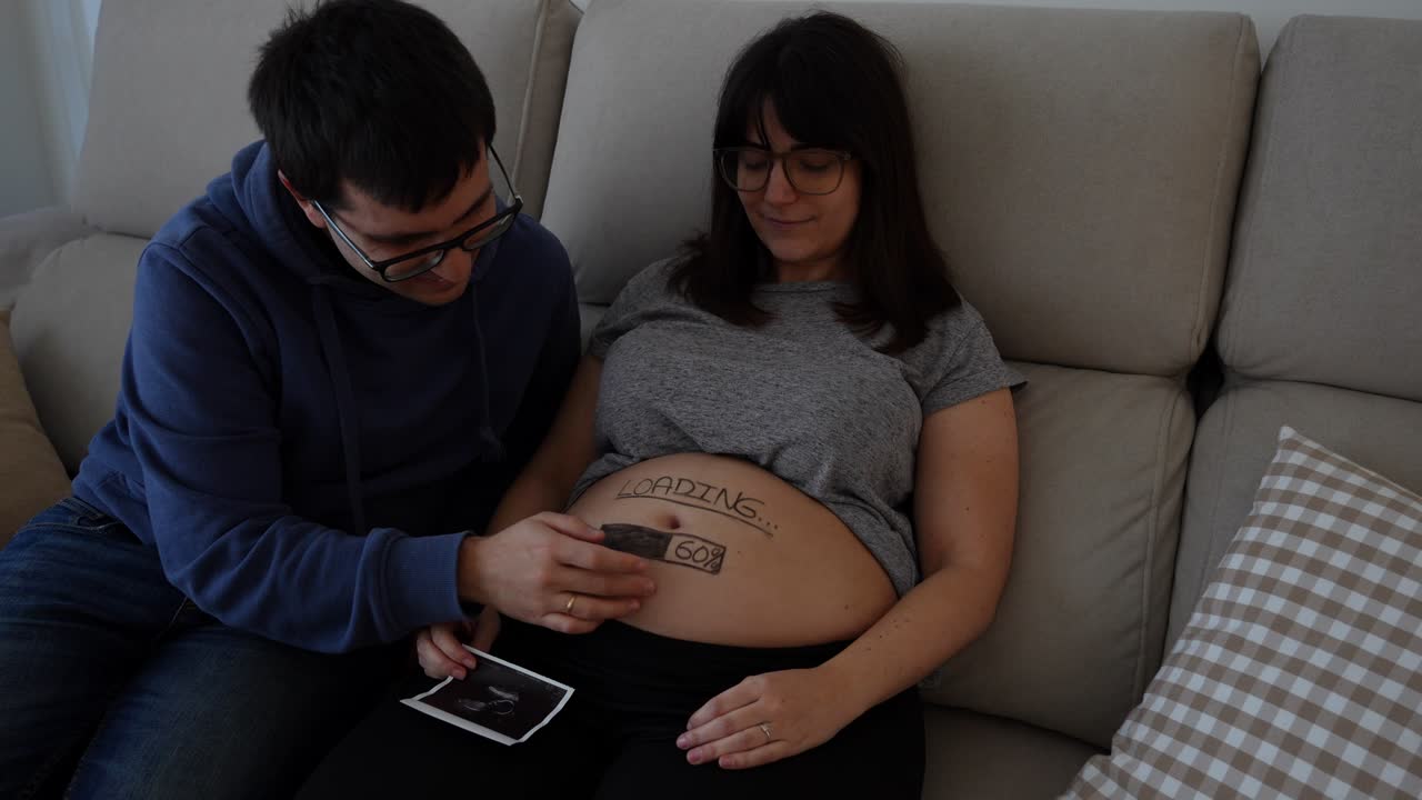 Happy young caucasian couple trying to feel the baby