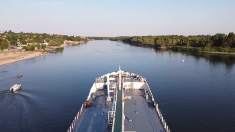 tanker ship on river with people on the shore