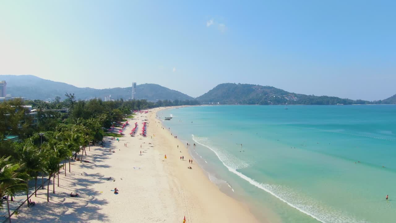 Tomas aéreas con dron de la playa de arena y mar al atardecer de verano en Patong Beach, Phuket, Tailandia.