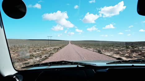 a long tarred road on the west coast of south africa with fluffy cumulus clouds
