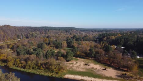 aerial fly-by of a river beach in rural outskirts of vilnius, lithuania during autumn