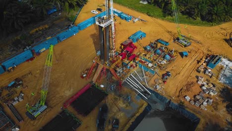estructura cinematográfica de plataformas de perforación y reacondicionamiento en tierra y equipo de plataformas para la exploración y explotación de petróleo en medio de la jungla rodeada de palmeras durante la puesta de sol