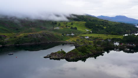 cinematic revealing drone shot of loch carron with low lying clouds covering the mountains, in the scottish highlands