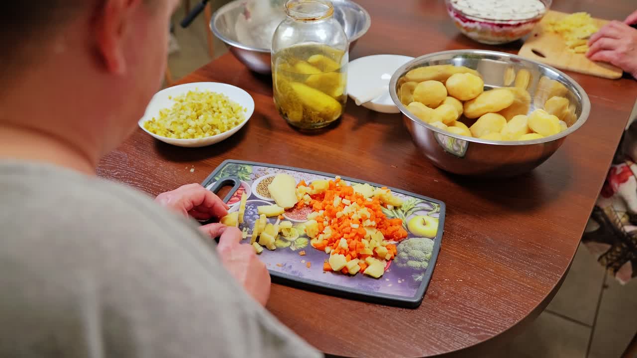 Potatoes and carrots chopped by hand for family-style Latvian rasols preparation