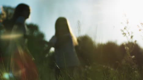 niñas jugando en un campo al atardecer
