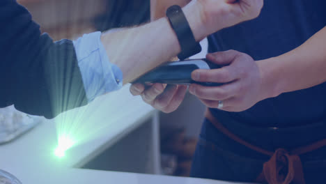 animation of light spots over caucasian man paying with smartwatch