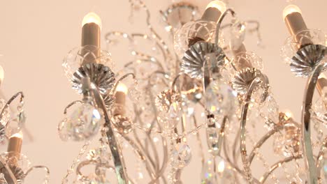 crystal chandelier hanging from ceiling with swinging light bulbs