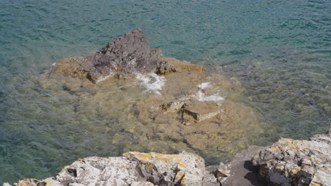 clear waves washing over rocky shoreline