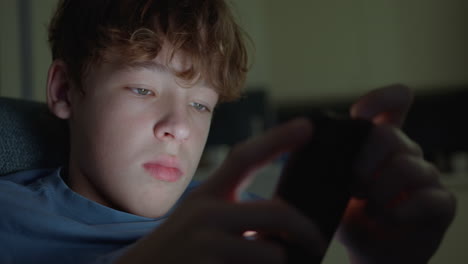 teenage boy using smartphone at night