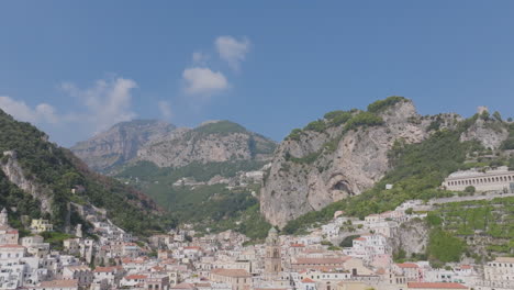 Wide-aerial-footage-that-pans-down-from-mountains-to-reveal-the-town-of-Amalfi-on-the-Amalfi-Coast-in-Italy