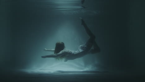 underwater gymnastics of a beautiful girl in a white dress