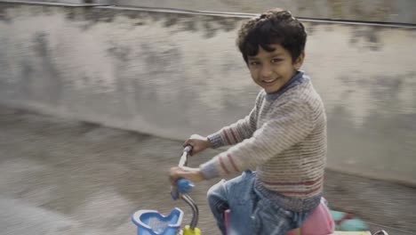 a young asian boy enjoying the weather while riding his bicycle on roof of his house