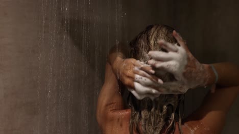 mujer lavándose el cabello en la ducha