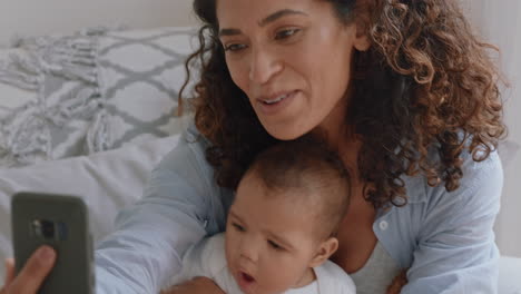 Feliz-Madre-Y-Bebé-Teniendo-Video-Chat-Usando-Un-Teléfono-Inteligente-Mamá-Compartiendo-El-Estilo-De-Vida-De-La-Maternidad-Sosteniendo-Al-Niño-Disfrutando-De-La-Comunicación-Por-Teléfono-Móvil-Con-La-Familia-En-Casa