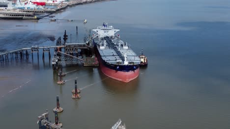 crude oil tanker ship loading at refinery harbour terminal aerial reverse view