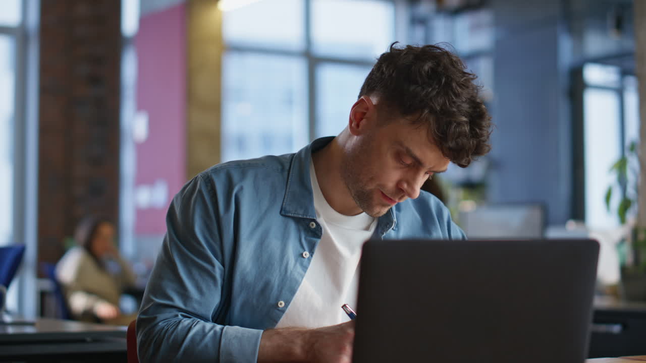 Busy man typing laptop writing copybook at workplace closeup. Freelancer working