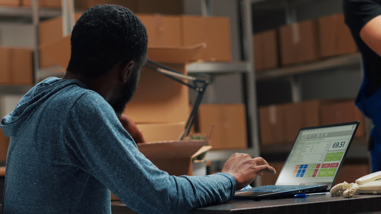 Man working on laptop in warehouse