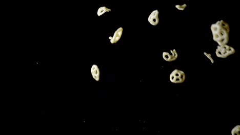 cámara lenta de patatas fritas volando sobre fondo negro