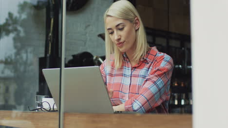 smiling woman having video call in a cafe