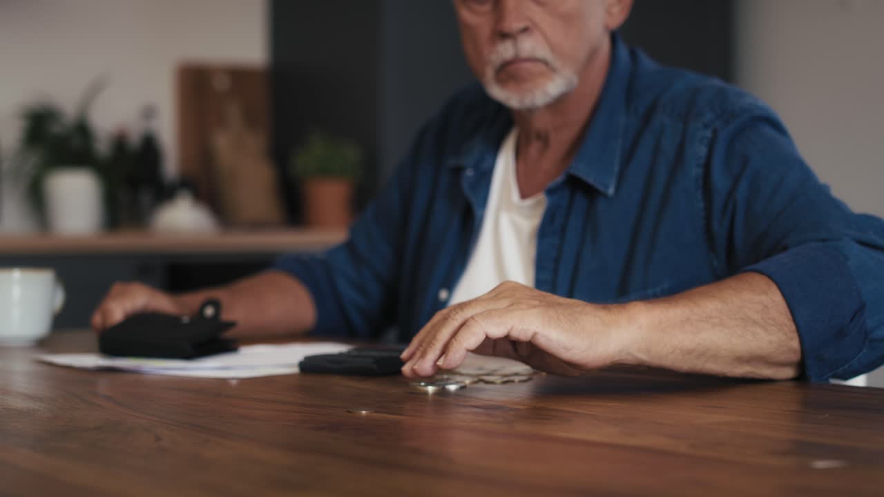 hombre mayor caucásico contando el presupuesto de la casa usando una calculadora.