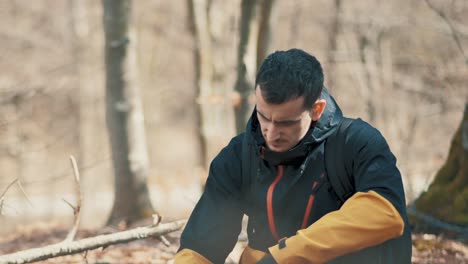 the hiker sits in the woods and looks at nature 4k