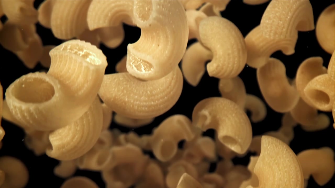 Pasta maccheroni cruda che cade al rallentatore