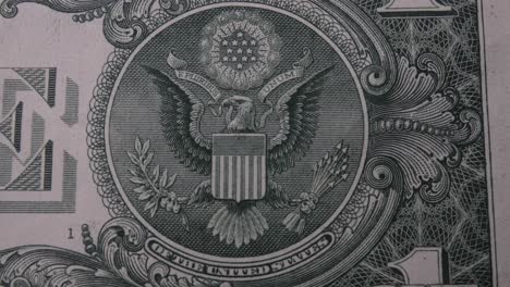 the great seal on the back of a 1 u.s. dollar bill. the banknote moves and pans from left to right and stops on the bald eagle emblem