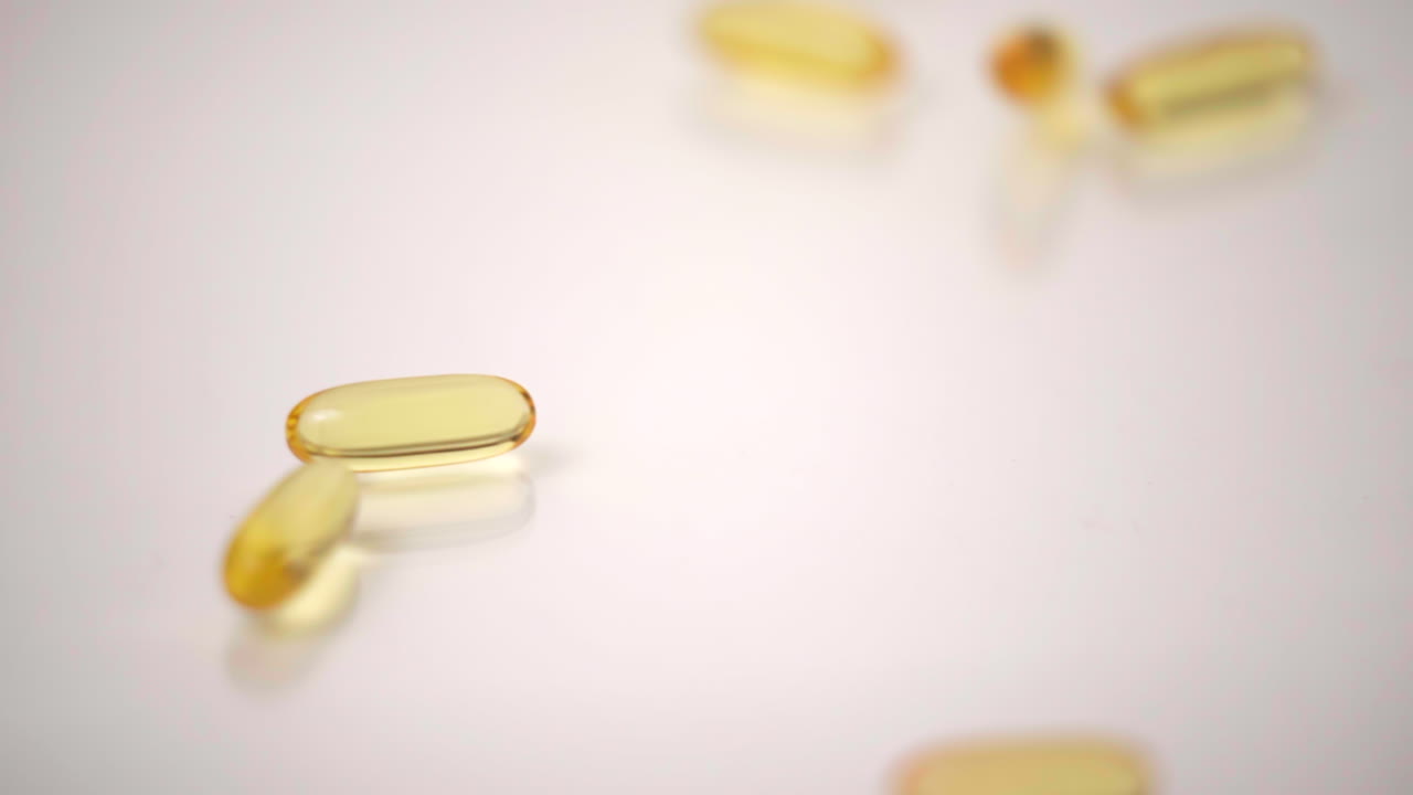 macro de pastillas amarillas caídas sobre fondo blanco