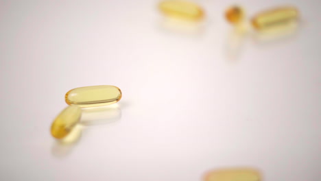 Macro-of-Yellow-Pills-Dropped-onto-White-Background