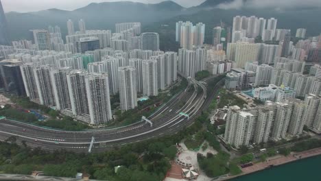 aerial view of hong kong. cityscape with high-rise buildings, lush green areas, and a winding highway. 4k.