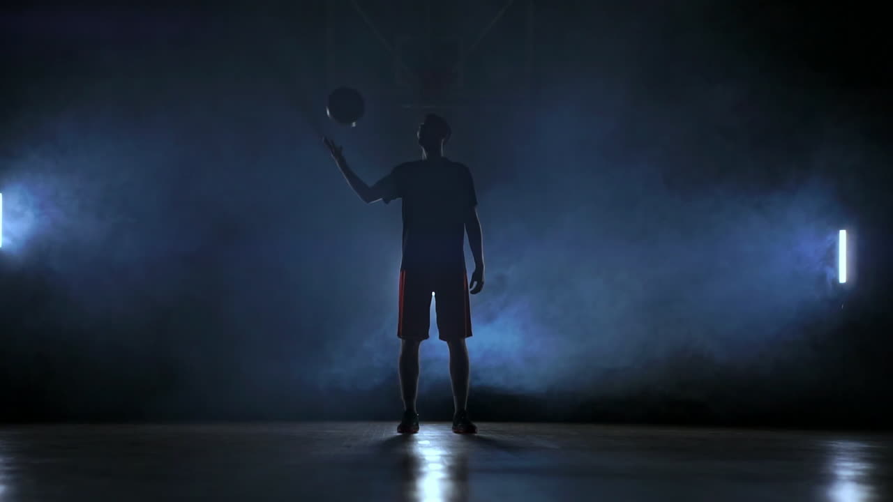 농구 선수 가 연기 에서 공 을 던지고 잡는다