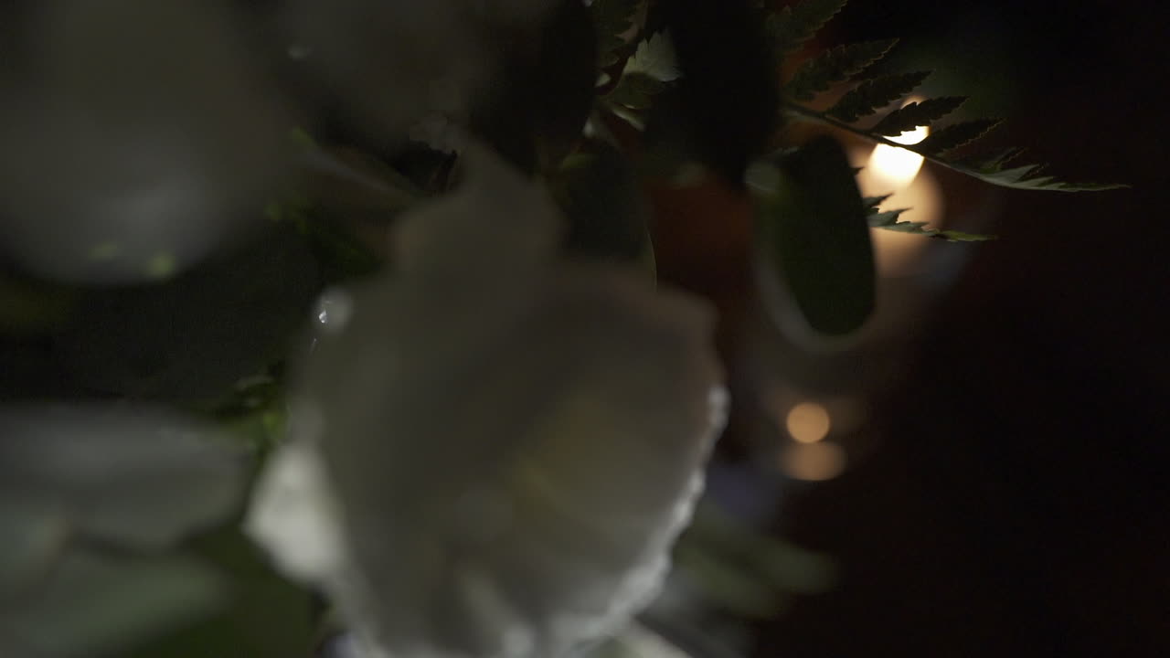 Decorative table at wedding event with glowing candles and blurred soft background lights