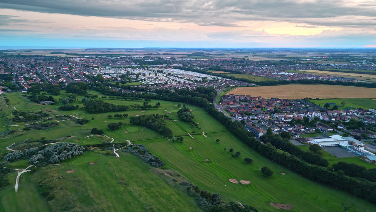 el video aéreo de drones captura skegness junto al mar al atardecer, mostrando el parque de vacaciones, la playa, el mar y las caravanas en paisajes panorámicos