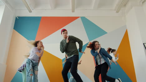 group of young people dancing in a colorful room