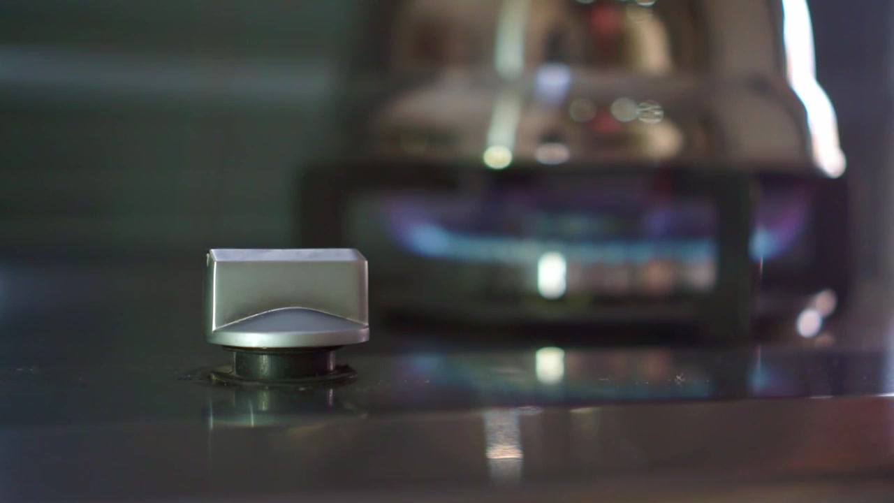 hand turning gas stove knob to ignite burner. Modern kitchen cooking concept, home appliance, culinary lifestyle footage.