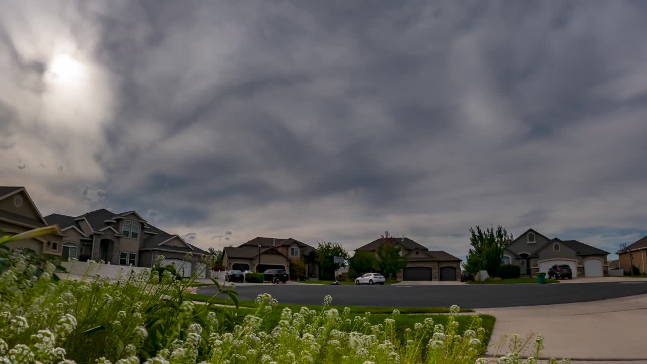 Dramatic cloudscape over an upper class neighborhood - tilt up, tilt down time lapse that can be played in a loop
