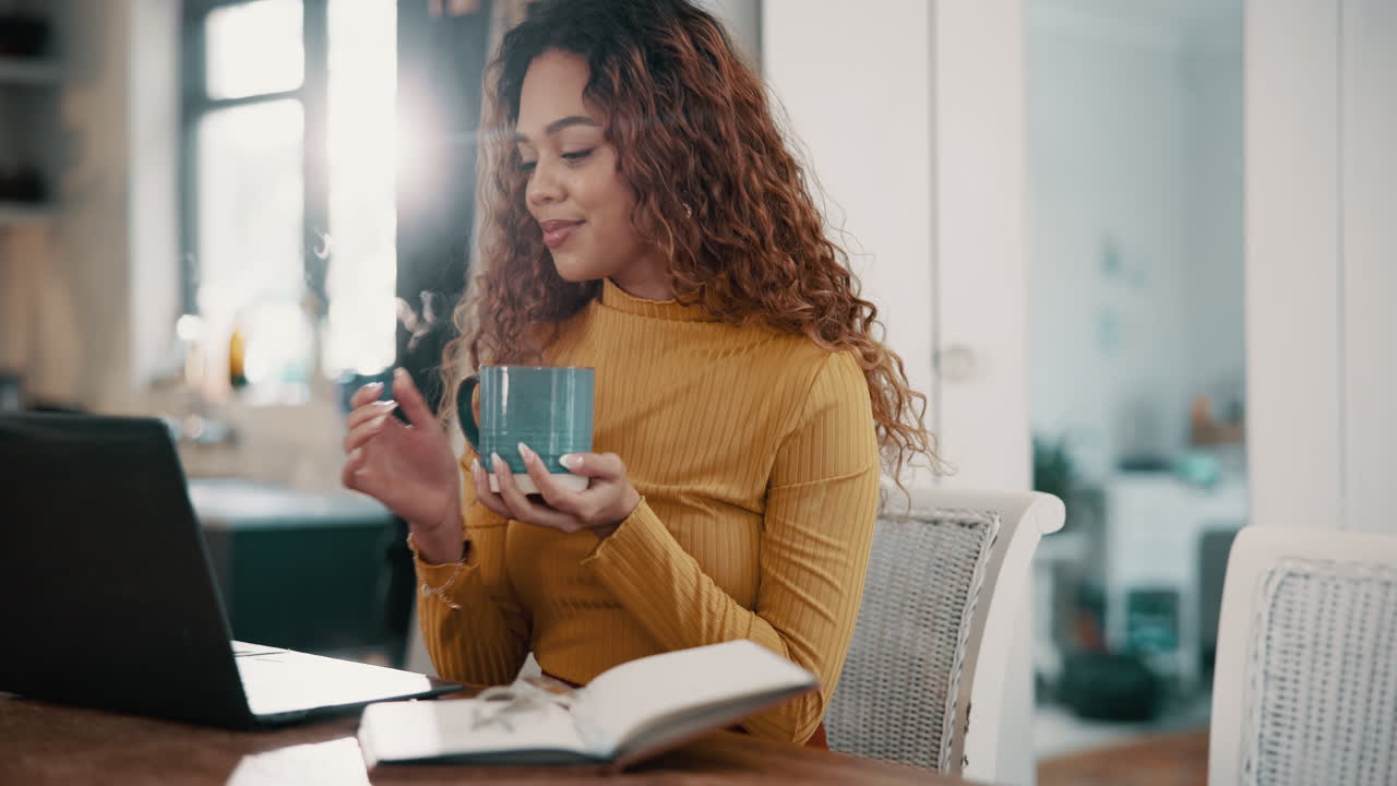 mujer trabajando en una computadora portátil en casa con una taza de café