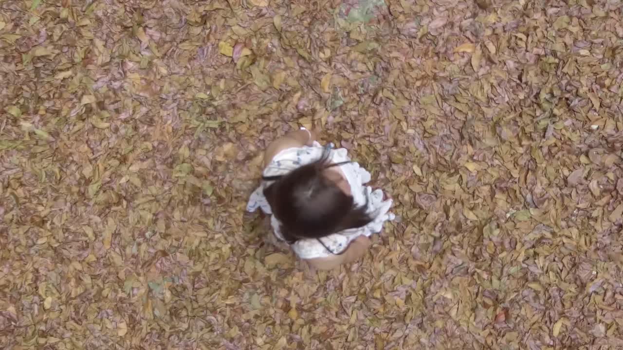 a girl stands with a top shot on leaves