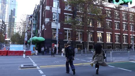 pedestrians crossing street near red brick building