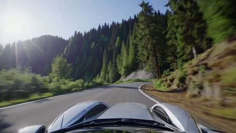 dynamic video captures a low-angle view from a sports car speeding through a winding forest road