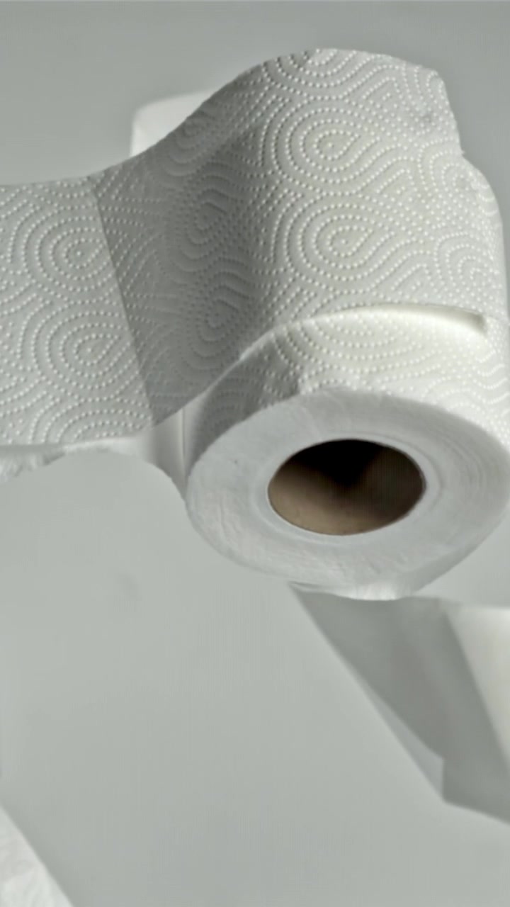White Paper Towel Rolls Floating and Unraveling in Slow Motion