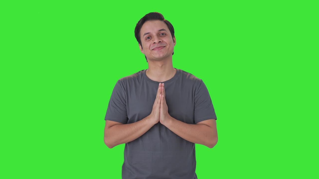 Happy Indian man doing Namaste and greetings Green screen