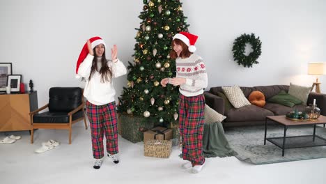 hermanas bailando alrededor del árbol de navidad