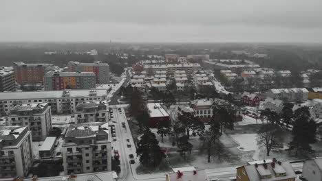 Backward-movement-of-drone-over-rural-Sweden-with-snow-covered-town