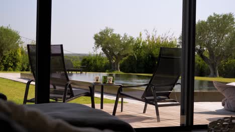 slow revealing shot of sun loungers sitting next to a pool with drinks on the table