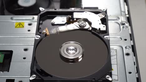 4k close up of a hard disk drive reading and writing data and internal structure for computer pc or server and cloud technology.