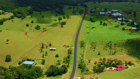 Idyllische-Landstraße-Zwischen-Grünen-Feldern-Und-Vegetation-In-Atherton-Tablelands,-Queensland,-Australien---Drohnenaufnahme-Aus-Der-Luft