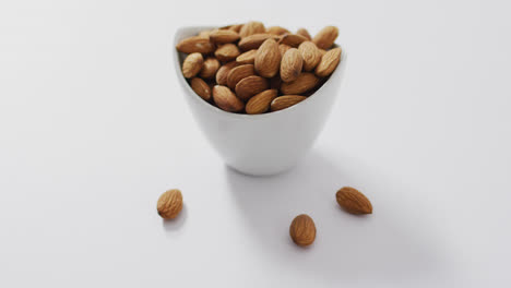 video de almendras en un tazón con fondo blanco