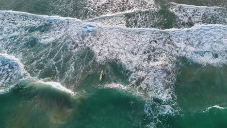 aerial view of surfer navigating ocean waves
