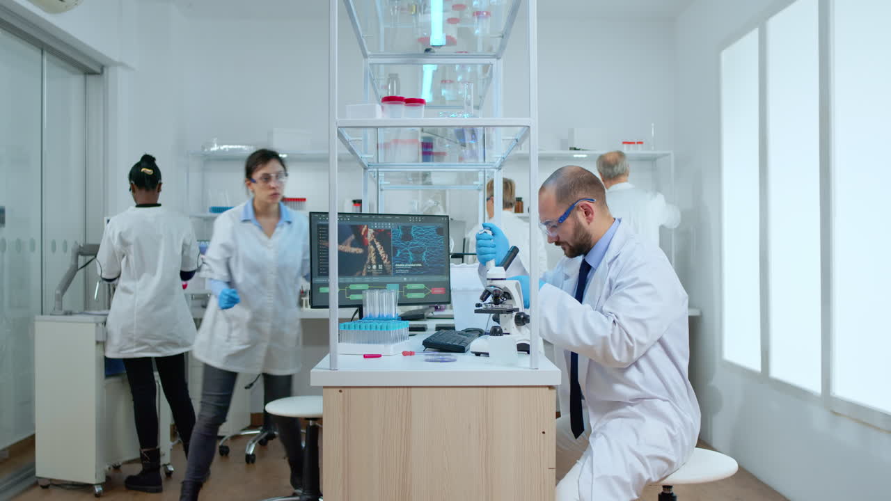 Man scientist positioning petri dish under microscope in laboratory